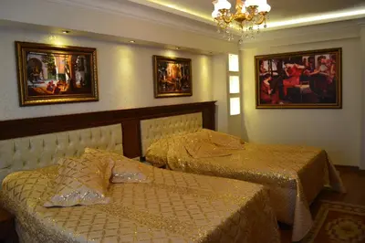 two beds in a room with pictures on the wall at Blue Istanbul Hotel in Istanbul