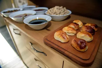 a table with buns on a cutting board and bowls of food at Tayahatun Hotel in Istanbul