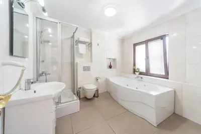 a white bathroom with a tub and a sink at Tayahatun Hotel in Istanbul