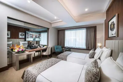 a hotel room with two beds and a desk at Vogue Hotel Supreme Istanbul in Istanbul