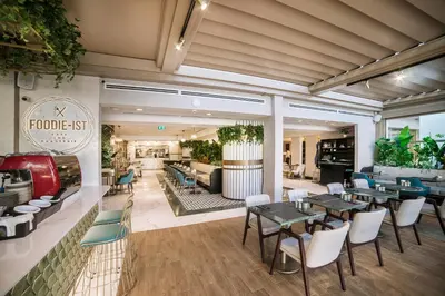 a restaurant with tables and chairs and a lobby at Vogue Hotel Supreme Istanbul in Istanbul