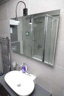 a bathroom with a sink and a shower and a mirror at Ramparts Hotel in Istanbul