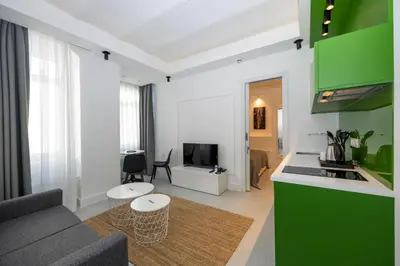a kitchen and living room with a couch and a tv at Juno Hotel Taksim in Istanbul