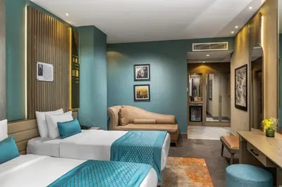 a hotel room with two beds and a couch at Aspera Hotel Altunizade in Istanbul