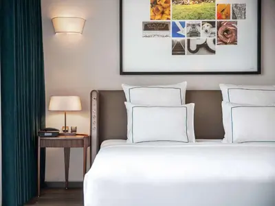 a bedroom with a white bed and a table with a lamp at Glens Palas Istanbul Nisantasi in Istanbul