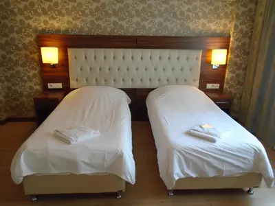 two beds in a hotel room with white sheets at City House in Istanbul