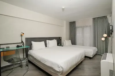 a hotel room with two beds and a desk at Faros Hotel Taksim-Special Category in Istanbul