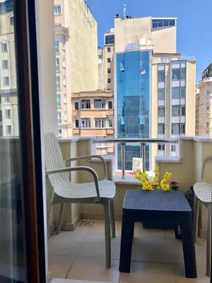 a balcony with chairs and a table and a window at Taksim House Suites in Istanbul