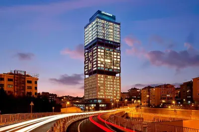 a tall building with lights on in a city at Le Meridien Istanbul Etiler in Istanbul