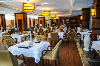 a dining room with white tables and chairs at Paradise Island Hotel in Gebze