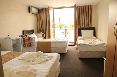 a hotel room with three beds and a balcony at holiday family apart in Istanbul