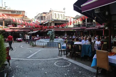 a crowd of people sitting around a fountain in a city at holiday family apart in Istanbul