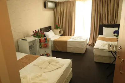 a hotel room with three beds and a window at holiday family apart in Istanbul