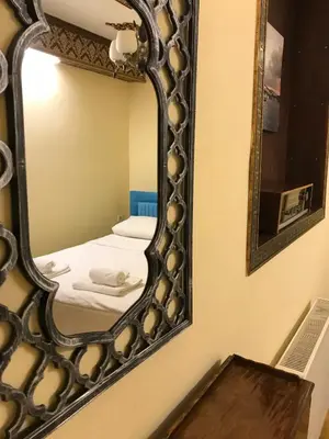a mirror on a wall with a bed in a room at Paris Garden Hotel Istanbul in Istanbul