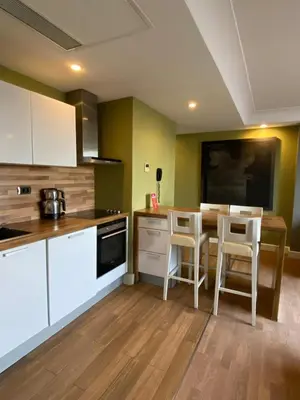 a kitchen with white cabinets and a table with stools at Taba Luxury Suites and Hotel in Istanbul