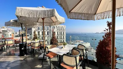 a restaurant with tables and chairs and a view of the water at The Wings Hotels Karakoy in Istanbul