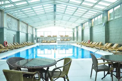 a large swimming pool with tables and chairs at Eser Diamond Hotel Spa & Convention Center İstanbul in Silivri