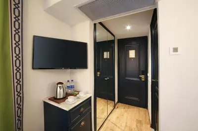 a room with a flat screen tv and a mirror at Hotel Ephesus Istanbul in Istanbul