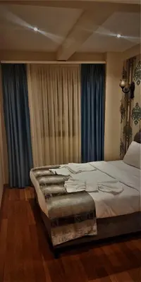 a bedroom with a large bed with blue curtains at By Historial Hotel Due in Istanbul