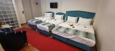 two beds in a room with a red rug at By Historial Hotel Due in Istanbul