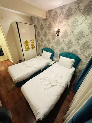 a room with two beds and a wall with wallpaper at By Historial Hotel Due in Istanbul