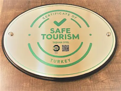 a plate with a safe tourism sign on a table at Bakirkoy Tashan Business & Airport Hotel in Istanbul