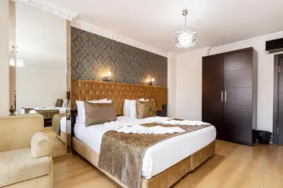 a bedroom with a large bed and a couch and a chair at Kumru Hotel in Istanbul