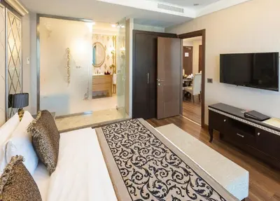 a bedroom with a bed and a television and a living room at Grand Makel Hotel Topkapi in Istanbul