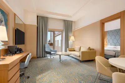 a hotel room with a bed and a living room at TRYP by Wyndham Izmit in Kocaeli