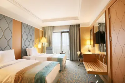 a hotel room with two beds and a desk at TRYP by Wyndham Izmit in Kocaeli