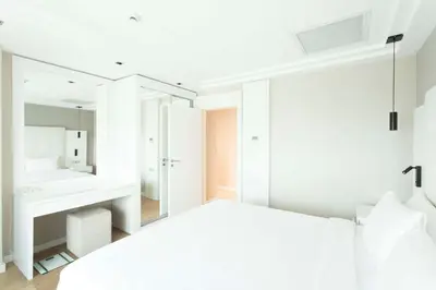 a white bedroom with a bed and a mirror at Radisson Residences Avrupa TEM Istanbul in Istanbul
