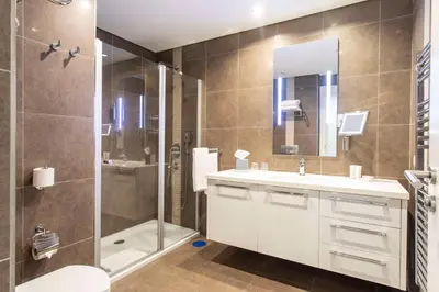 a bathroom with a shower and a sink and a mirror at Radisson Residences Avrupa TEM Istanbul in Istanbul