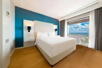 a bedroom with a white bed and a large window at Radisson Residences Avrupa TEM Istanbul in Istanbul