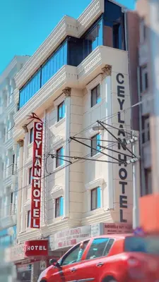 a building with a red car parked in front of it at Ceylan Hotel in Bursa