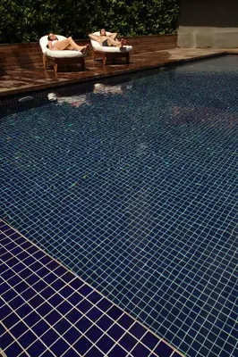 two people laying in chairs next to a swimming pool at Opera Hotel Bosphorus - Preferred Hotels and Resorts in Istanbul