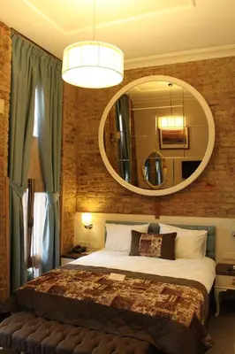 a bedroom with a large bed and a mirror at Collage Pera Hotel in Istanbul
