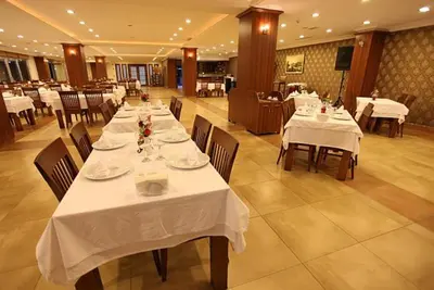 a restaurant with tables and chairs with white table cloth at Shilla Hotel in Velimeşe