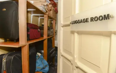 a room with auggage room sign next to a shelf with luggage at Sultan Hostel & Guesthouse in Istanbul