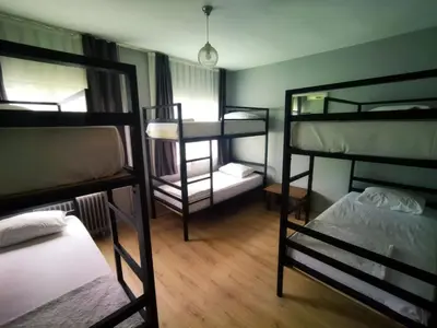 a room with three bunk beds and a table at Sultan Hostel & Guesthouse in Istanbul
