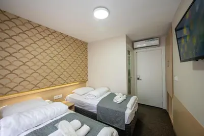a hotel room with two beds and a flat screen tv at Hotel Melita in Istanbul