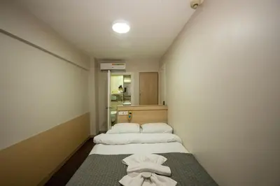 two beds in a small room with a mirror at Hotel Melita in Istanbul