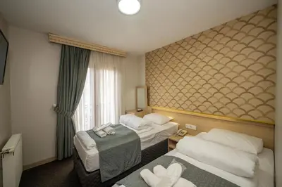 a hotel room with two beds and a window at Hotel Melita in Istanbul
