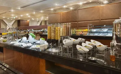 a restaurant with a bar with white dishes on it at DoubleTree by Hilton Istanbul-Avcilar in Istanbul