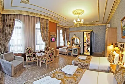 a hotel room with two beds and a living room at Glamour Classic Hotel Istanbul Sirkeci in Istanbul