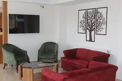 a living room with a red couch and two chairs at Longoz Hotel in Igneada