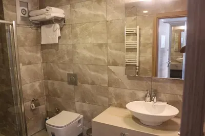 a bathroom with a sink and a toilet and a mirror at Longoz Hotel in Igneada
