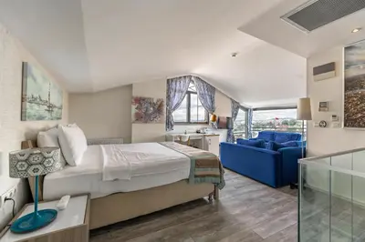 a bedroom with a bed and a blue couch at Elanaz Hotel in Istanbul