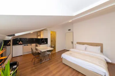 a bedroom with a large bed and a kitchen at Joy Suites in Istanbul