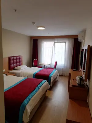 a hotel room with two beds and a table at BURSA ŞAHiN HOTEL in Bursa