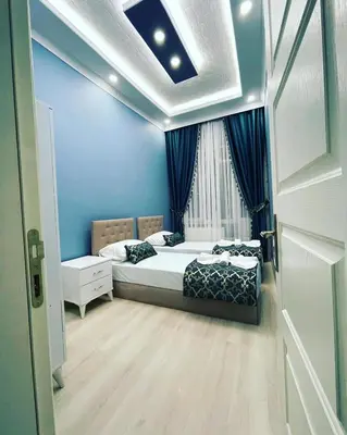 a bedroom with two beds and a blue wall at donat suites apartment in Istanbul